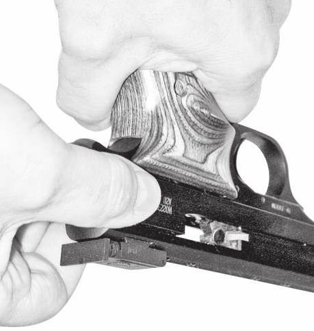 With the muzzle still pointing in a safe direction, and with your finger off the trigger and outside the trigger guard, grasp the sides of the slide from the rear with your thumb and fingers, and