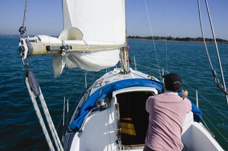 eliminate the need for a topping lift) Ease the halyard to the marked Reef position, pull in the reef line then tension the halyard. The sail is then reefed.