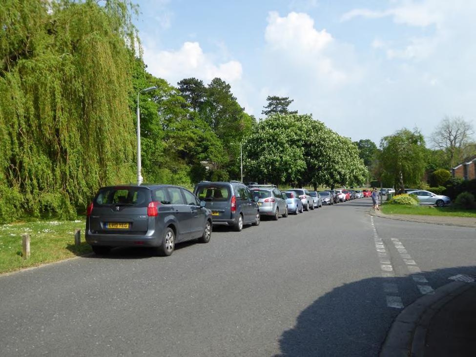 Cars parked immediately opposite a road junction where there is limited visibility for cars exiting by