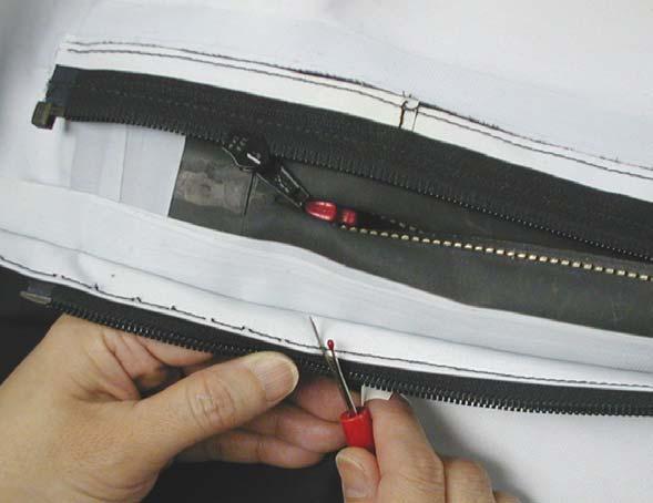 b. Cut the stitching around the zipper (see figure 48); ensuring the beginning of the stitching is