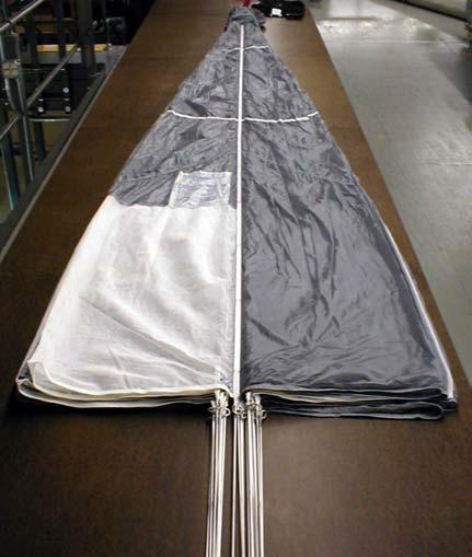 23. Apply tension to the canopy, flake the canopy in the usual manner, then lay the canopy on the table