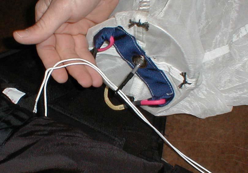 64. Pass the rod through the grommet on the pilot chute base, then insert your SAFETY pull-up cord as shown.