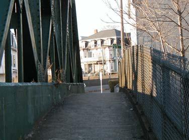 The structure of the bridge restricts access when considering an at-grade crossing. Figure 4.32 Sidewalk along Cross St.