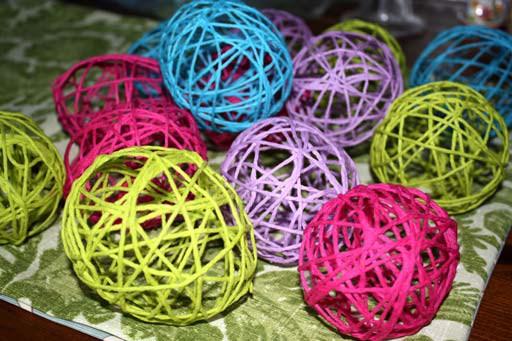 Then lay the end of one skein of yarn on the balloon and wrap the yarn around the balloon until it is nicely covered. Wrap the yarn so the balloon is covered randomly or in a pattern.