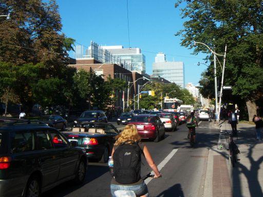 Busy street, no parked cars, bike lane Safer, neutral impact