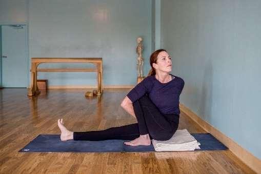 muscles on the left away from the spine as you move your trunk toward the bent leg. Return to Dandasana. Bend your left leg, turning to the left with your left hand on the wall and repeat.
