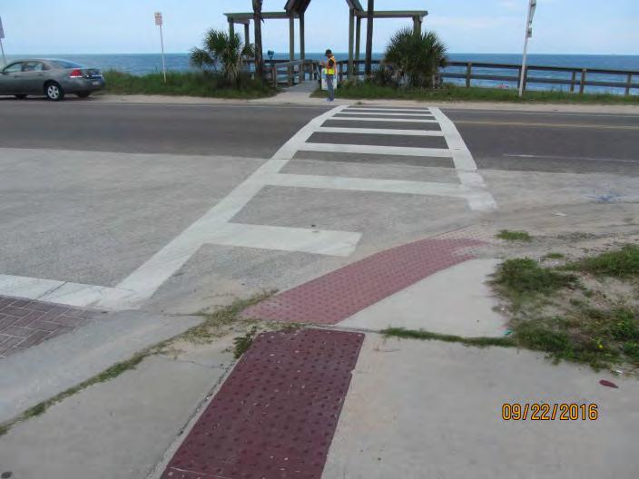 As shown in Figure 4 and Figure 42, sand and debris is tracked onto the crosswalks and detectable warning surfaces because of this.