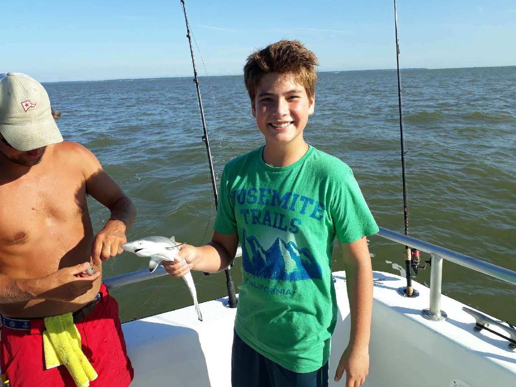 Brodie Livesay (green t-shirt) Johnson City, Tennessee is holding a just caught soon to be released juvenile shark!