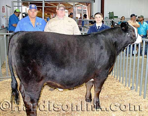 Elijah Mitchell and the Reserve Grand Champion Fat Steer and one of the buyers Over the past years, there has been agony from defeat and ecstasy of victory for individual children selling pork and