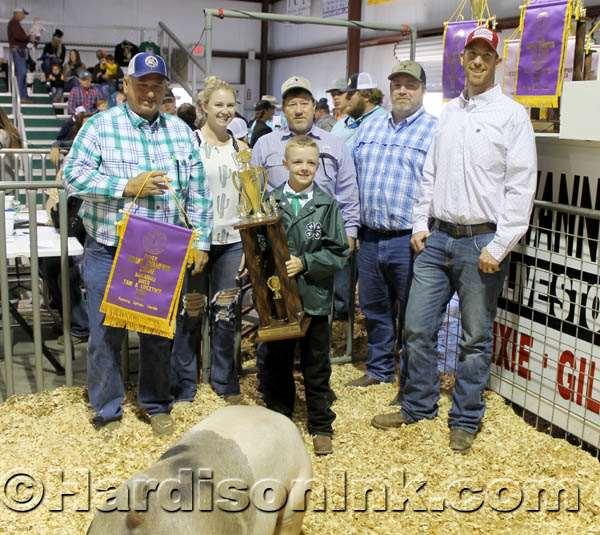 Mason Boyd (left) stands holding his Grand Champion
