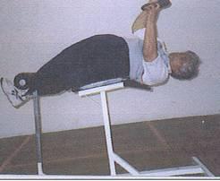 1 shows the starting position, the athlete rests on one hip with the ankle tucked under the stops. The weight is picked up from the floor and swung to the position in Fig.2.