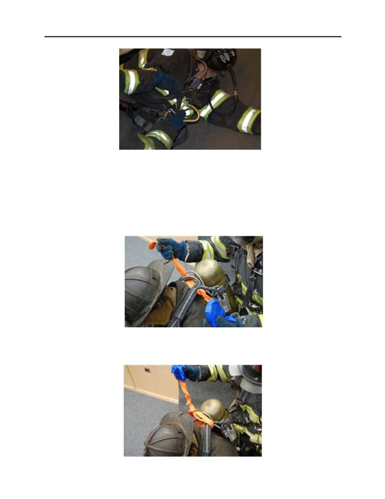 Photo 2 1.10 Once both of the distressed member s SCBA shoulder straps are positioned inside the hook of their personal harness hook, release the gate of the hook. 1.11 Prior to tightening the distressed member s SCBA straps, webbing should be placed through the top end of the shoulder straps to make a girth hitch.
