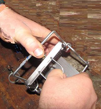 Rule number 1, at all times, is NEVER have your fingers above the trap in the area bounded by the bar (C) and the chassis (I) when the trap is set even if the safety hook is on.