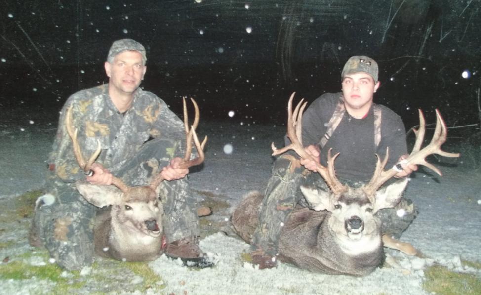 Trophy Muleys Two hunters and two trophy mule deer. The snow is falling in the South Willow Creek Pasture where these hunters are proudly displaying a very successful hunt!