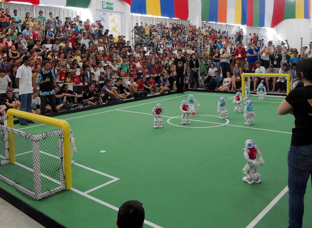 Fig. 1 NAO robots playing in an SPL game during RoboCup 2014 SPL Drop-in Player Competitions greatly improved upon the 2013 challenge in both scale and participation.
