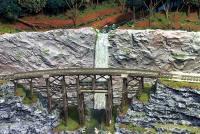 The high waterfall perfectly compliments the curved trestle. The space between the trestle and the waterfall further enhances the scene.