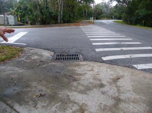 Sidewalk ramps do not have detectable warning surfaces, and there is a drainage inlet within existing sidewalk/crosswalk on northwest corner of intersection.
