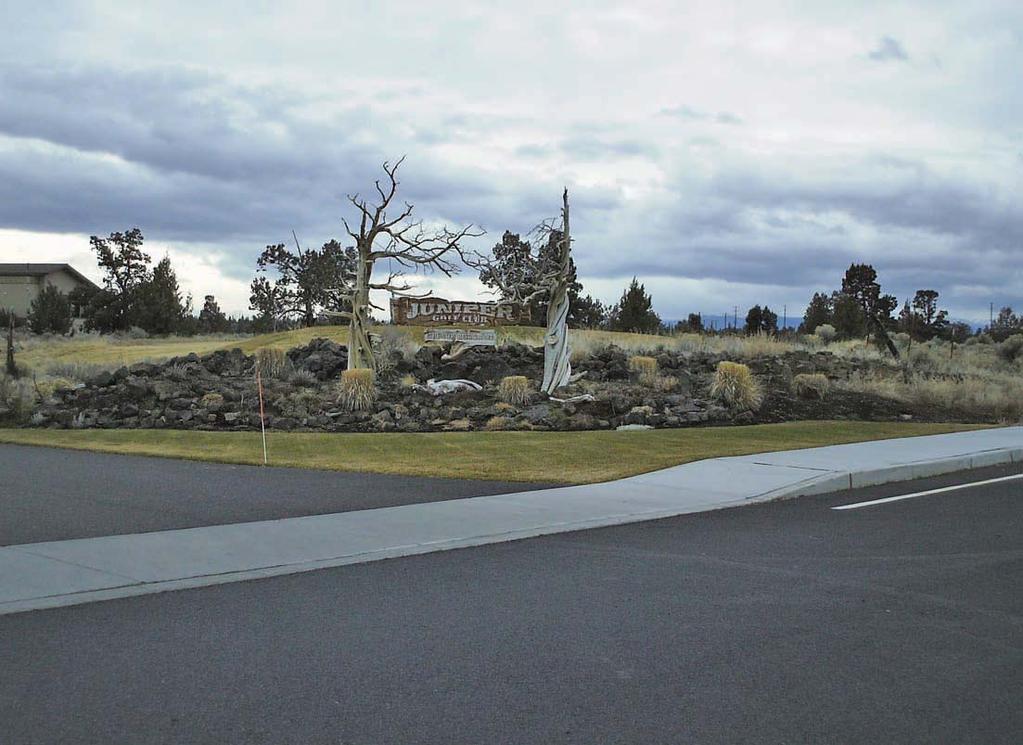 At the main driveway entrance, the signage is a combination of juniper logs and snags