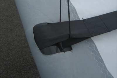 If supplied, use the two short elastic straps and tie them on to the rear wing bar wire brace and