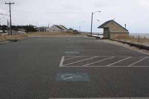 Coastal engineering structures include 3 stone groins and a low-lying timber bulkhead separating the beach from the parking lot.
