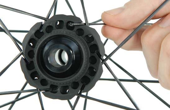Unlace the spoke so that it can be pushed tension-free through the hub. 3.