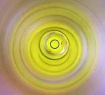 Look through the open end of the tube at the black circle printed on the yellow base of the tube; this is the marker.