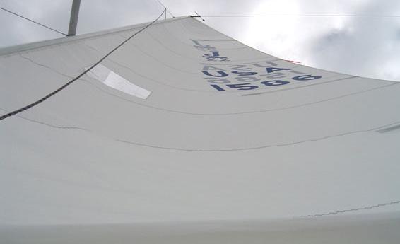 As the breeze increases, gradually drop the traveler to reduce helm, while at the same time trim the mainsheet.