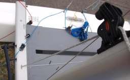 From the bottom, pass the retrieval end of the halyard between the beam and the jib track. 3.