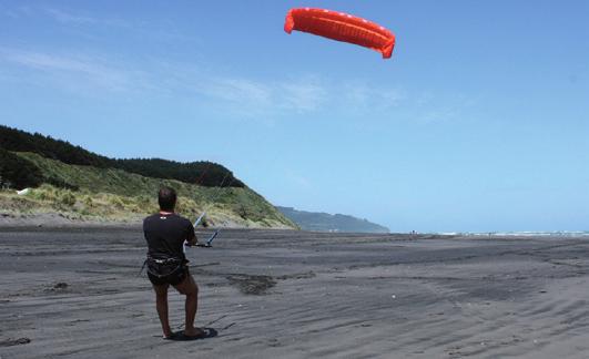 Step backwards while pushing the bar forward. The kite will slowly inflate and take off.