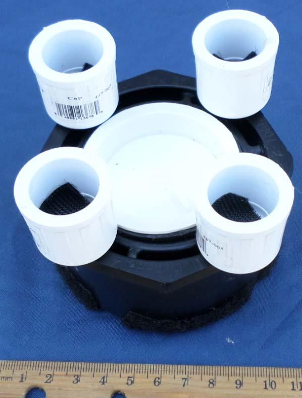 1. Cut a 2 cm length of 2-inch PVC pipe. Insert the 2 cm length of pipe into the 2 cm opening on the reducer bushing. 2. Insert a 2-inch knockout cap (Home Depot model #39101, Internet #100137732, Store SKU #508257) into the 2-inch pipe.