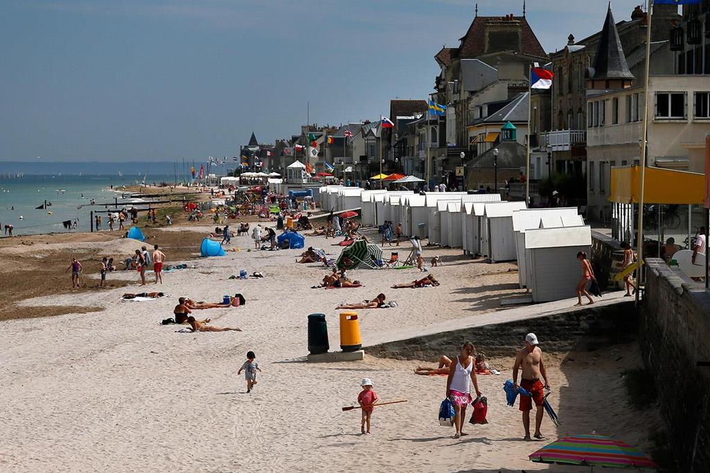 Tourists enjoy the sunshine on the former Juno Beach D-Day landing zone, where