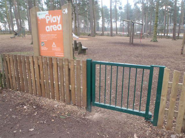 They open inwards and are self closing. The whole of the play area is surfaced with woodchip.