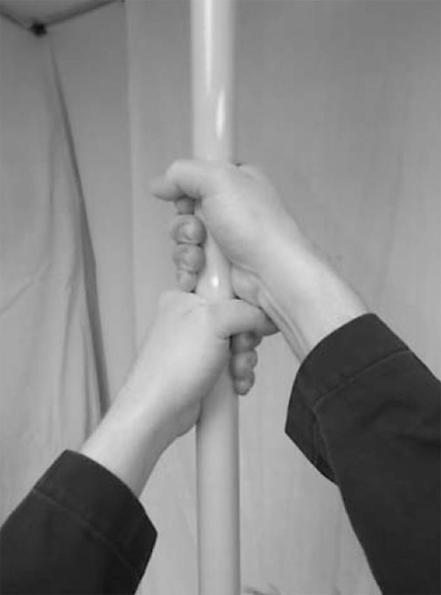 . Figure 8.29.5.4(a) Position of Test Subject's Body, Arms, and Hands with Respect to Pole. (Photo courtesy of Intertek Testing Services.