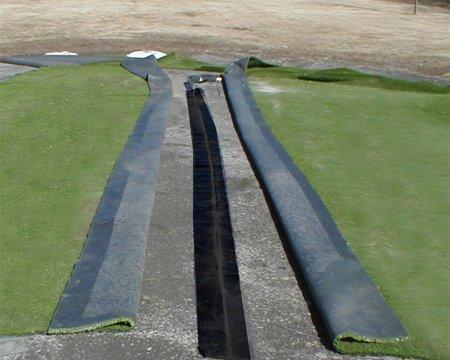 seamed back about four feet, as shown here. Each piece of turf comes with a three to four inches of salvage (cloth piece on the edges of the turf), which must be removed before seaming.