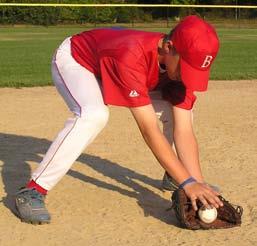 Step to ball with right foot, bend knee and lower chest, and bring glove to ground. Then, step with left foot (feet apart), center body behind ball, stay low, and slide glove and hand forward.