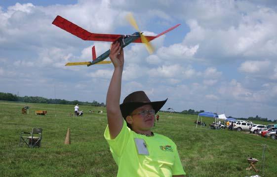 Free Flight Day 4 Recap Cade Fedor poses with his rubber-powered model. Day 4 of Free Flight dawned as the first day with a forecast of no rain with north-northeast winds from 5-15 mph.