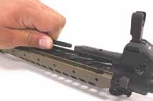 Cup the bolt carrier group in one hand and, with a suitable punch or the tip of a cartridge, push out the firing pin retainer in to your cupped
