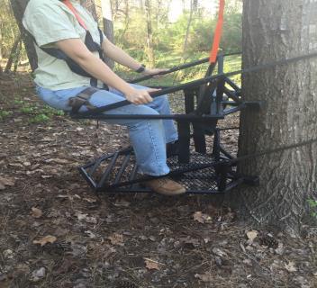 7 7. Sit (top or seat platform) on the shooting rest facing the tree and insert your boots into the