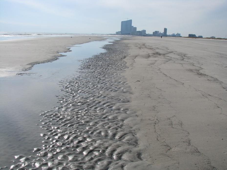 shoreline. This view shows the wide, dry beach, due to the sediment trapping effect of the north Absecon Inlet jetty.