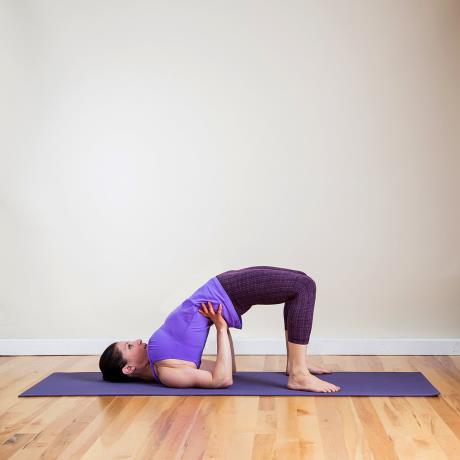 11. Half-Wheel From Seated Spinal Twist, inhale to bring your torso back to center. Exhale to lie on your back. Bend your knees, and place your feet flat on the floor.