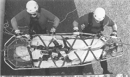Rigging the litter tenders connections to the lowering system. Each attendant rigs a connector to use in attaching to the system, as described above for single-line litter lowers.