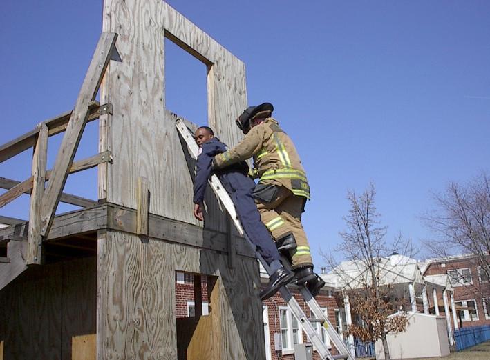 Conscious victims should be helped onto the ladder into a normal climbing position and the firefighter should descend the ladder as shown in Figure 21.