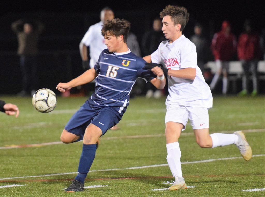 Unionville s Garrett Pinkston (15) clears the ball while being pressured by Wilson s Devven Frey during their PIAA 4A semifinal Tuesday at Upper Perkiomen.