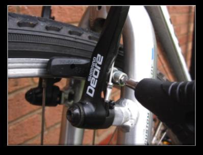 You should adjust the cable tension so that when the brake levers are applied halfway the brakes are fully engaged.