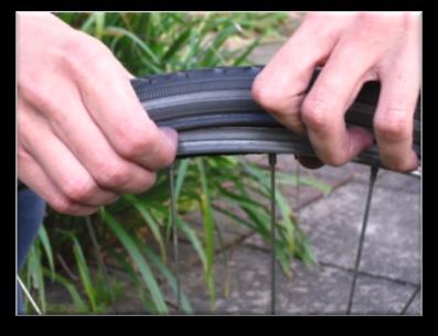 Work your way around the tyre. This can be a little tough. When you get stuck remove any air from the inner tube.