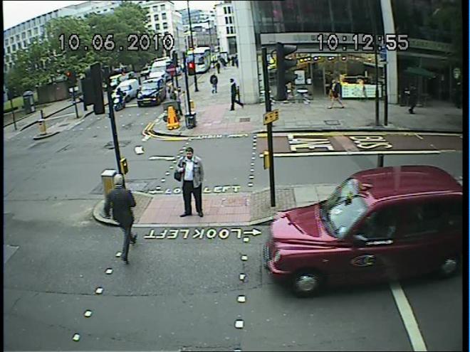 Conflict Level 2. The pedestrian crossed the road during the red man and was on the crossing when the taxi started to move from the stop line.