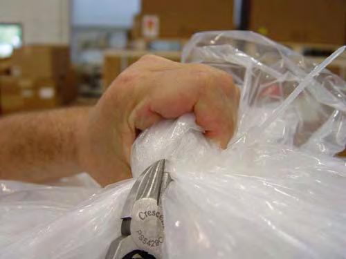 Using a pair of scissors, cut the plastic wrap from the A5/A3 near the back of the unit, using care