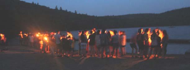 A small flame from the closing campfire is used to light a candle from each cabin; the cabin Footprints Award