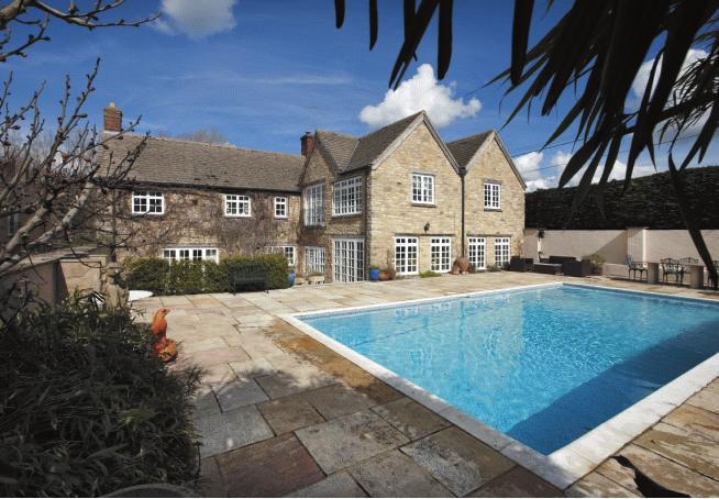 DUNS TEW GRANGE DUNS TEW OXFORDSHIRE A substantial farmhouse with outdoor heated swimming pool, range of stabling/outbuildings and gardens and grounds of approximately 3.