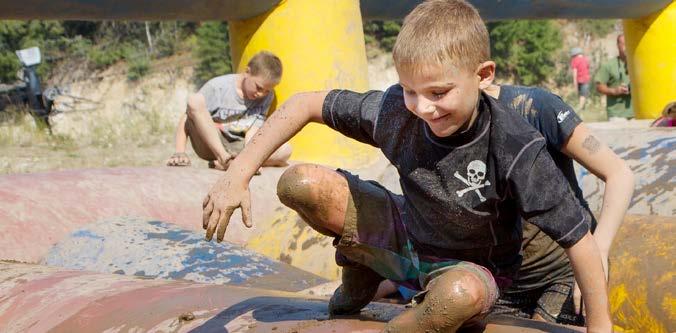 A young boy goes over an obstacle during a mud run. Just for Kids Some mud runs are made for children as young as three.